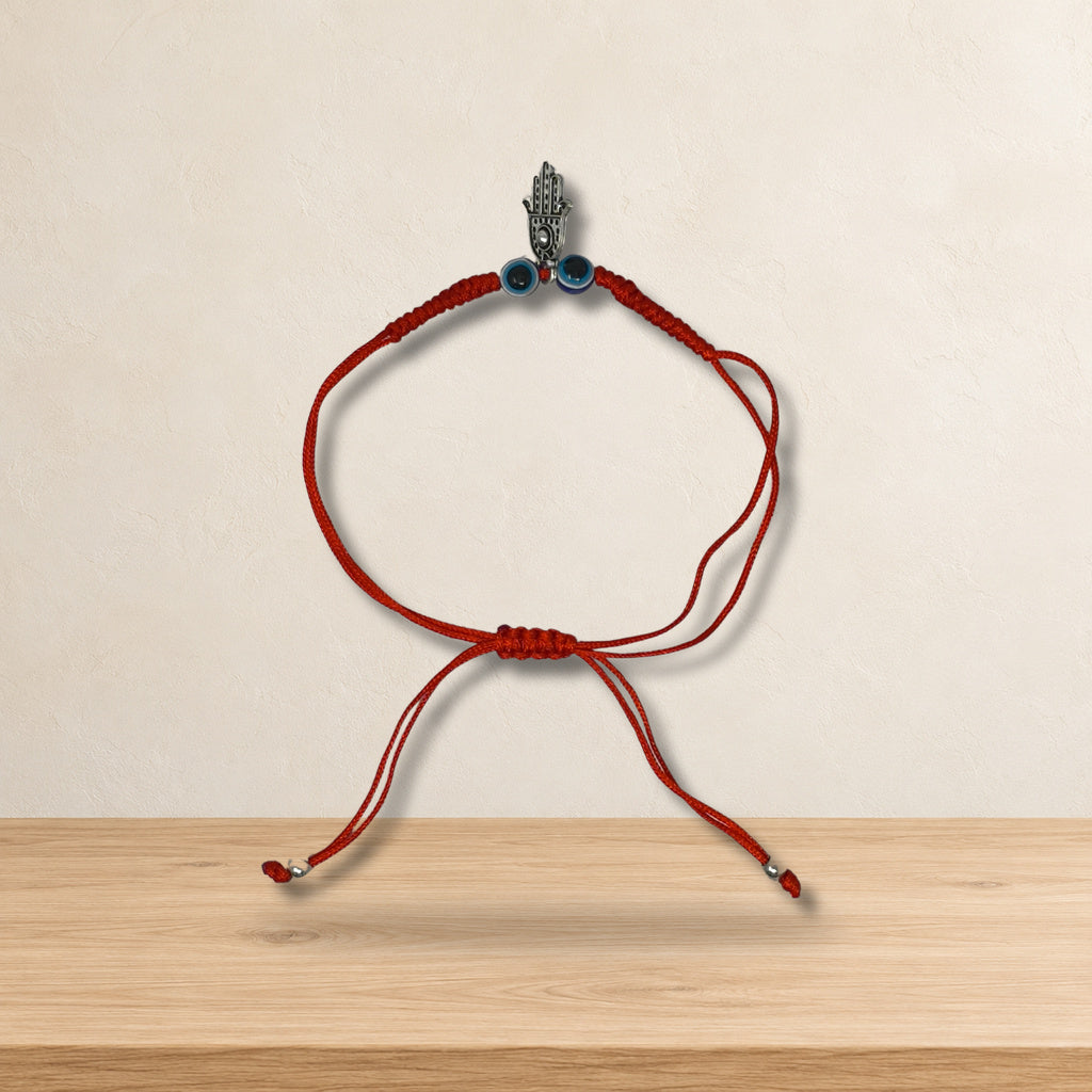 Pulsera de hilo rojo Hamsa con 2 ojitos 102102 — ambientación en estudio claro