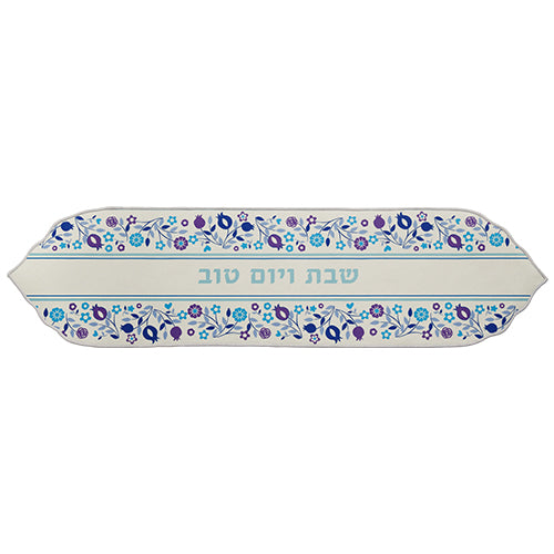 Camino de mesa Art Judaica 49055 con motivos florales en azul y morado sobre una base clara e inscripción en hebreo, 120 × 30 cm.